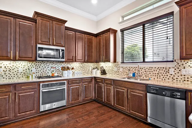 a kitchen with stainless steel appliances granite countertop wooden cabinets a sink and a stove