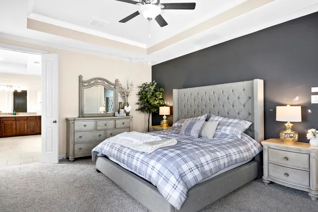 a bedroom with a large bed and a chandelier