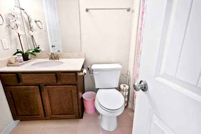 a bathroom with a granite countertop sink toilet and a mirror