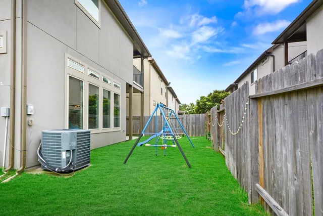 a view of backyard with a slide and wooden fence