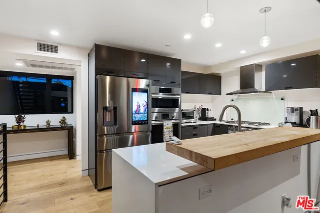 a kitchen with stainless steel appliances granite countertop a sink refrigerator and cabinets