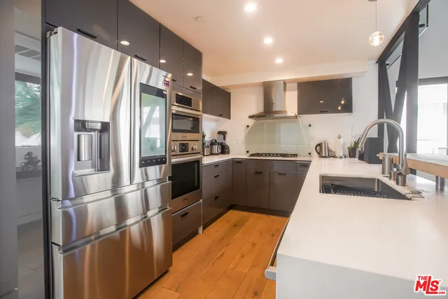 a kitchen with stainless steel appliances granite countertop a refrigerator and a sink