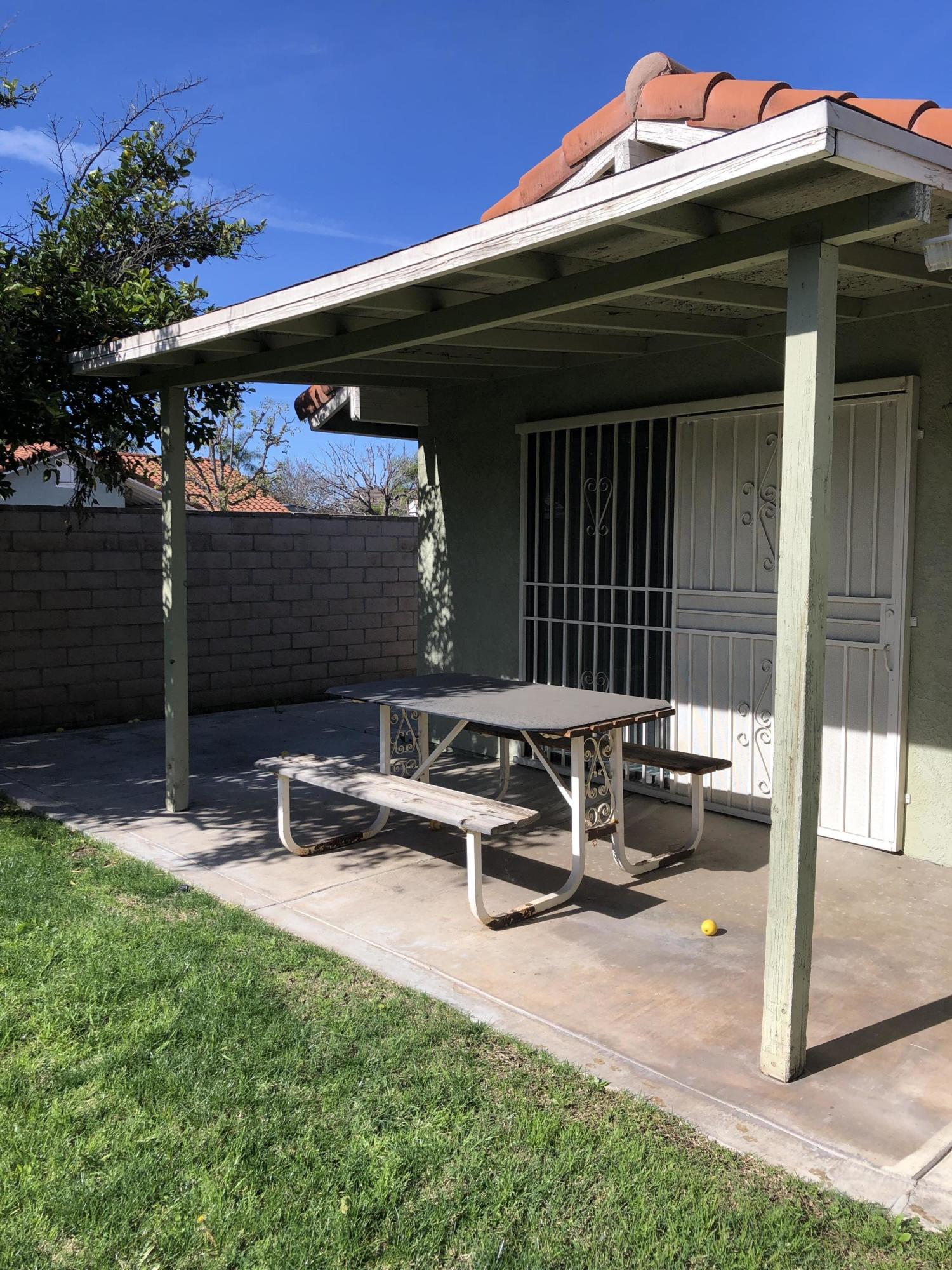 11368 Rancho Del Oro Drive Riverside, CA 92505 - Photo 20 of 20 a view of a patio with table and chairs with wooden fence