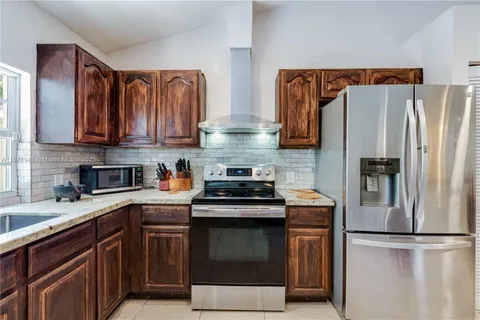 a kitchen with stainless steel appliances granite countertop a refrigerator stove and sink