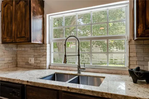 a kitchen with granite countertop a sink and a window