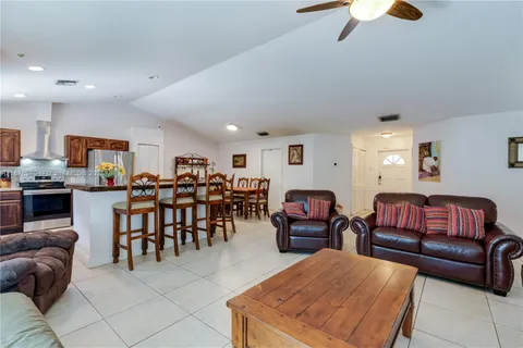 a living room with furniture kitchen view and a dining table