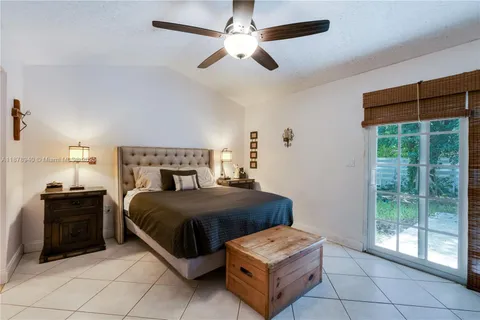 a bedroom with a bed and a chandelier fan