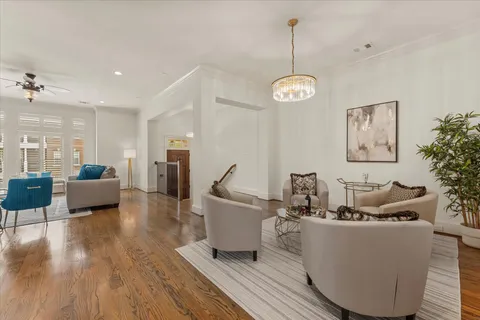 a living room with couches and kitchen view with wooden floor