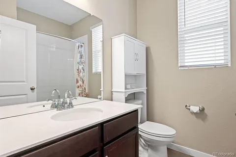 a bathroom with a sink toilet and a mirror