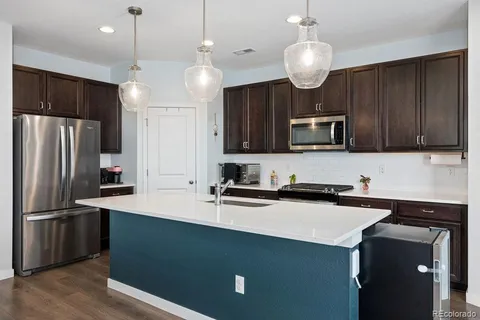a kitchen with kitchen island a sink stainless steel appliances and cabinets