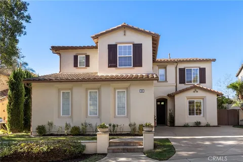 an aerial view of residential houses with outdoor space and trees