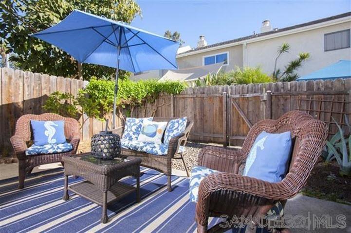 815 Del Mar Downs Road, Unit C Solana Beach, CA 92075 - Photo 15 of 19 a view of a patio with couches chairs under an umbrella
