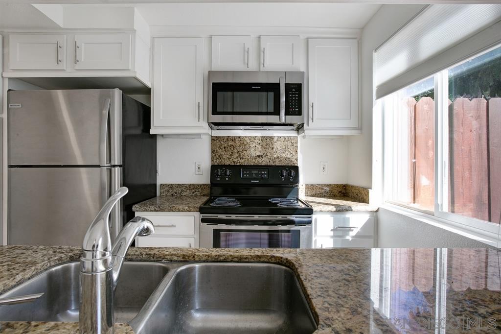 815 Del Mar Downs Road, Unit C Solana Beach, CA 92075 - Photo 7 of 19 a kitchen with granite countertop a refrigerator stove and microwave