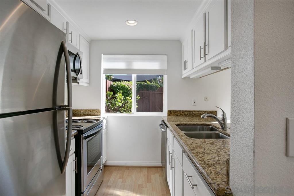 815 Del Mar Downs Road, Unit C Solana Beach, CA 92075 - Photo 8 of 19 a kitchen with granite countertop a refrigerator and a sink