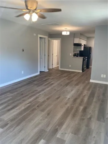 a view of empty room with wooden floor