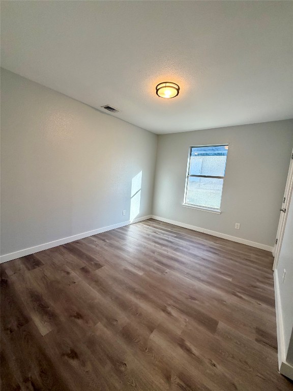 511 Central Avenue, Unit A Elgin, TX 78621 - Photo 8 of 10 an empty room with wooden floor and windows