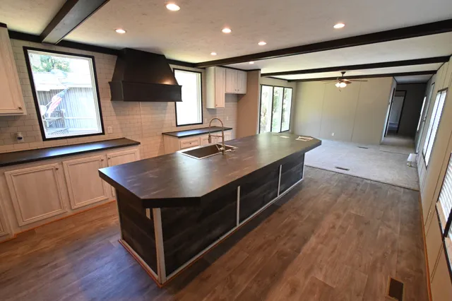 a kitchen with kitchen island a sink appliances and a window