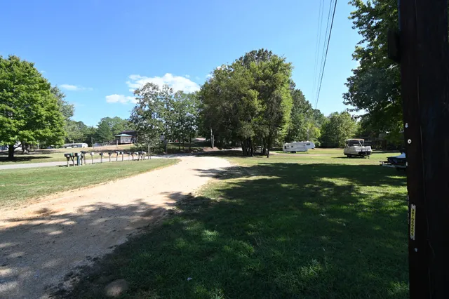 a view of grassy field with benches and trees all around