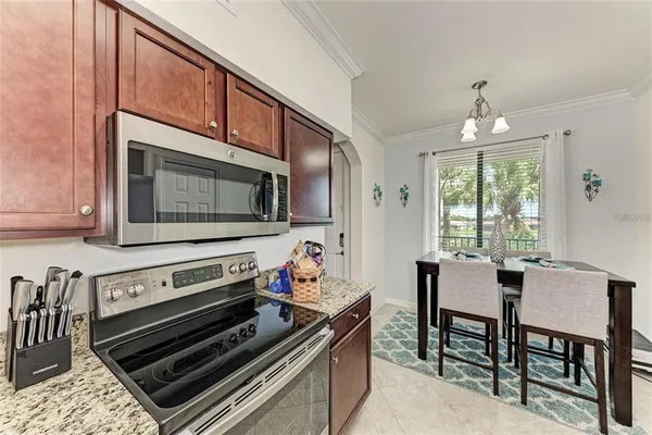 a kitchen with a stove a microwave and living room
