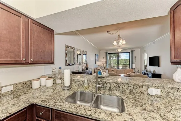 a kitchen with granite countertop a sink and a refrigerator