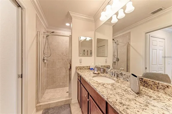 a bathroom with a granite countertop sink mirror and shower