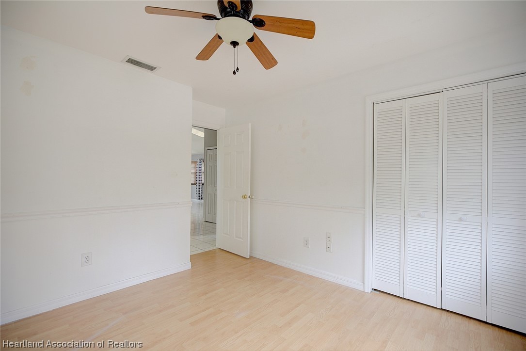 6304 Gunner Terrace Sebring, FL 33875 - Photo 7 of 41 an empty room with a hallway and a chandelier fan