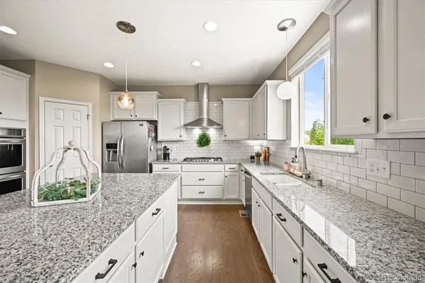a large kitchen with granite countertop a sink stainless steel appliances and cabinets