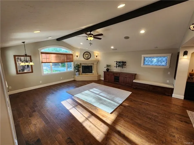 a view of a big room with wooden floor and windows
