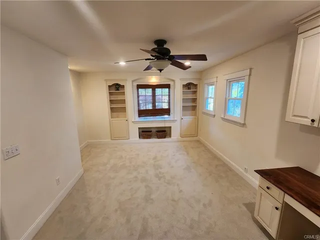 en empty room with windows and a ceiling fan