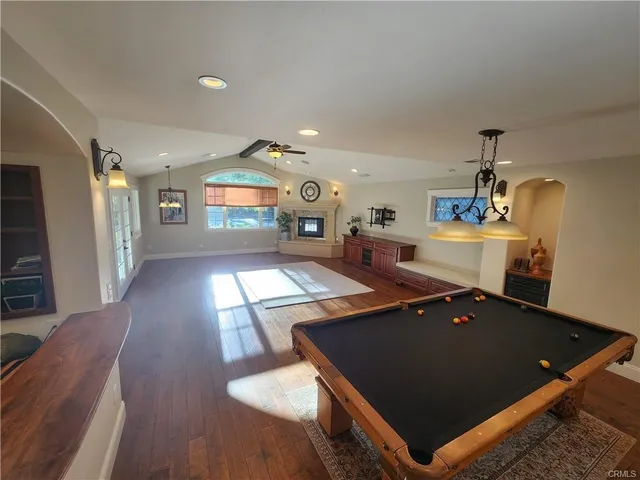 a living room with stainless steel appliances furniture a window and a dining table