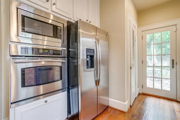 a kitchen with stainless steel appliances and wooden floor