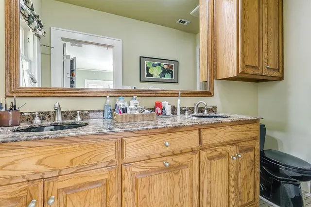 a bathroom with granite countertop a sink and a mirror
