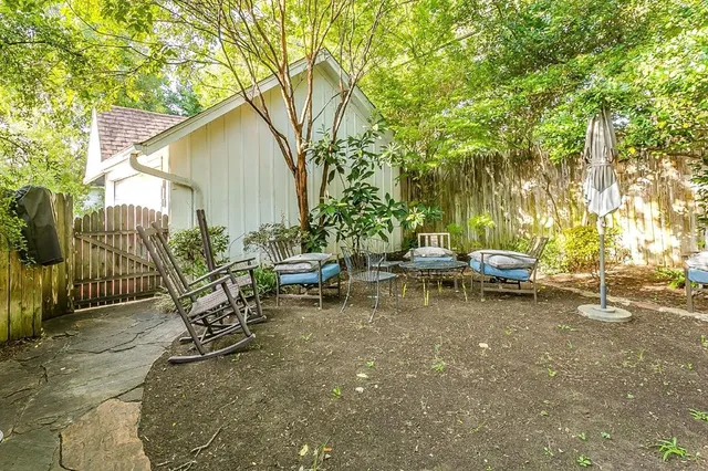 a view of a small yard with a patio and a bench
