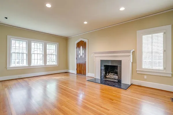 a view of an empty room with window and fire place