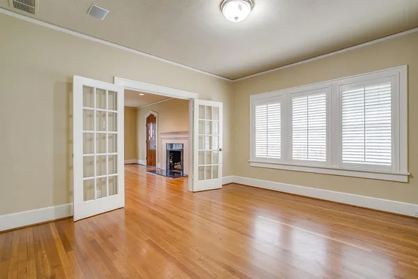 an empty room with wooden floor and windows