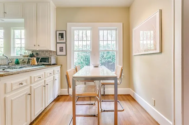 a kitchen with white cabinets and wooden floor