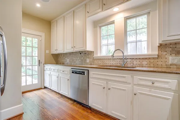 a kitchen with granite countertop white cabinets and a window