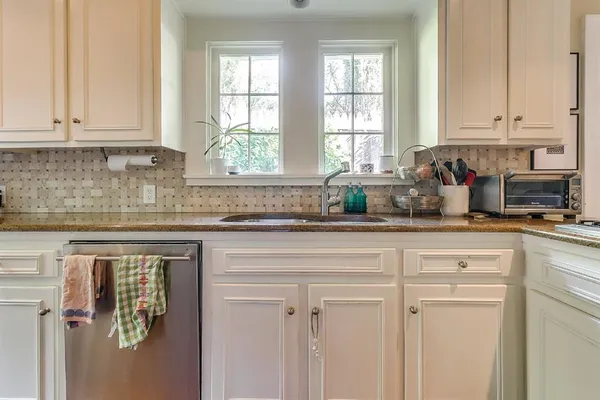 a kitchen with stainless steel appliances white cabinets and a window