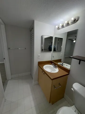 a bathroom with a toilet a sink and mirror