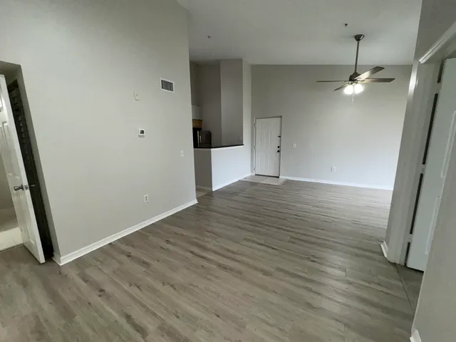 an empty room with wooden floor and windows