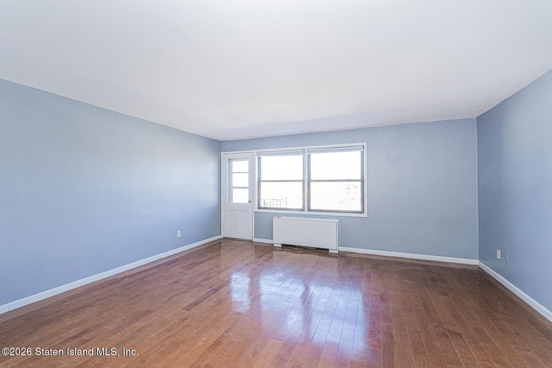 1000 Clove Road, Unit 7F Staten Island, NY 10301 - Photo 14 of 16 an empty room with wooden floor and windows