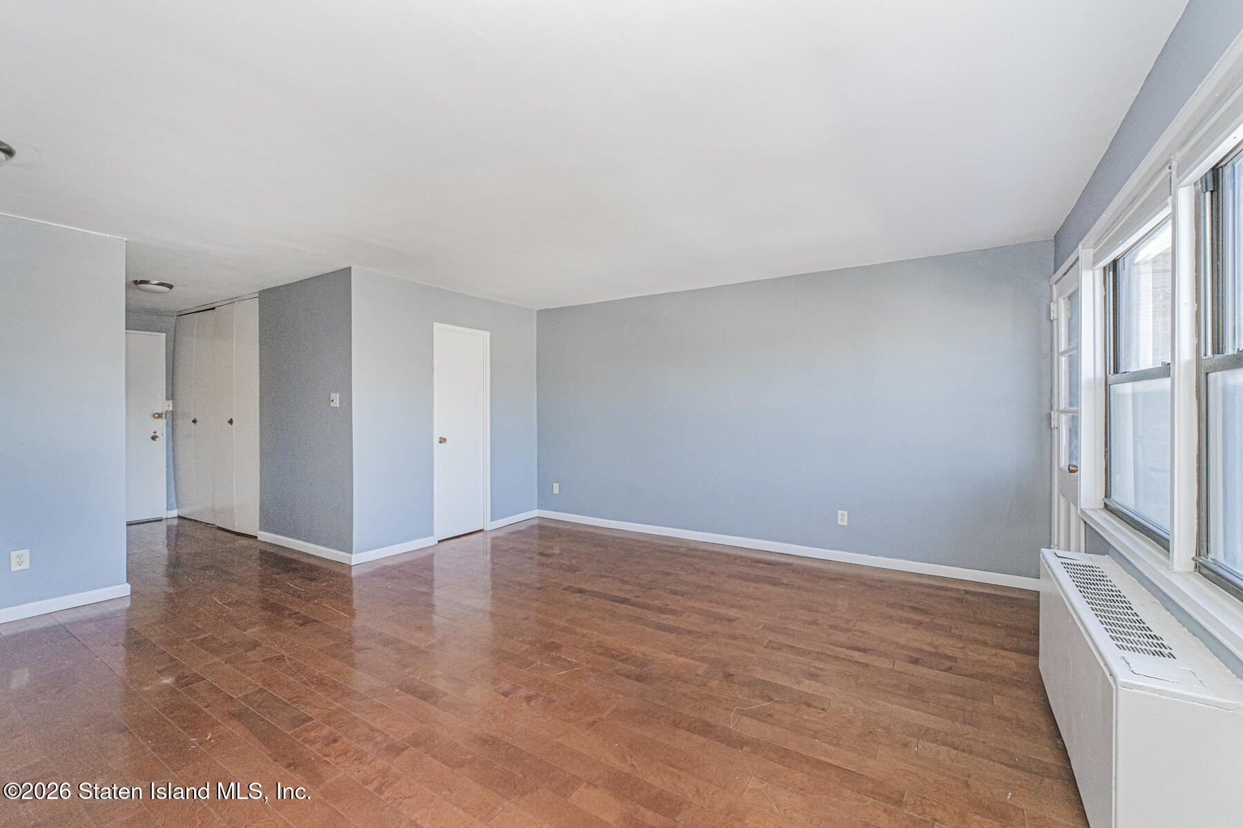 1000 Clove Road, Unit 7F Staten Island, NY 10301 - Photo 6 of 16 a view of an empty room with wooden floor and a window