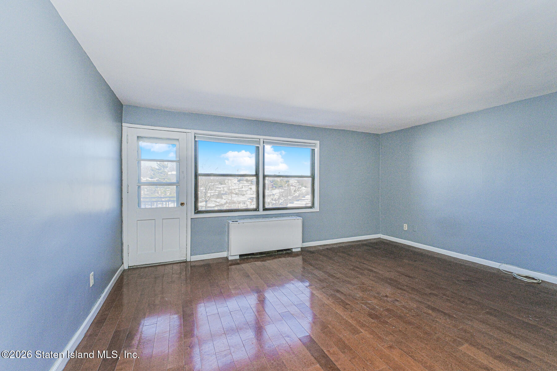 1000 Clove Road, Unit 7F Staten Island, NY 10301 - Photo 8 of 16 an empty room with wooden floor and windows