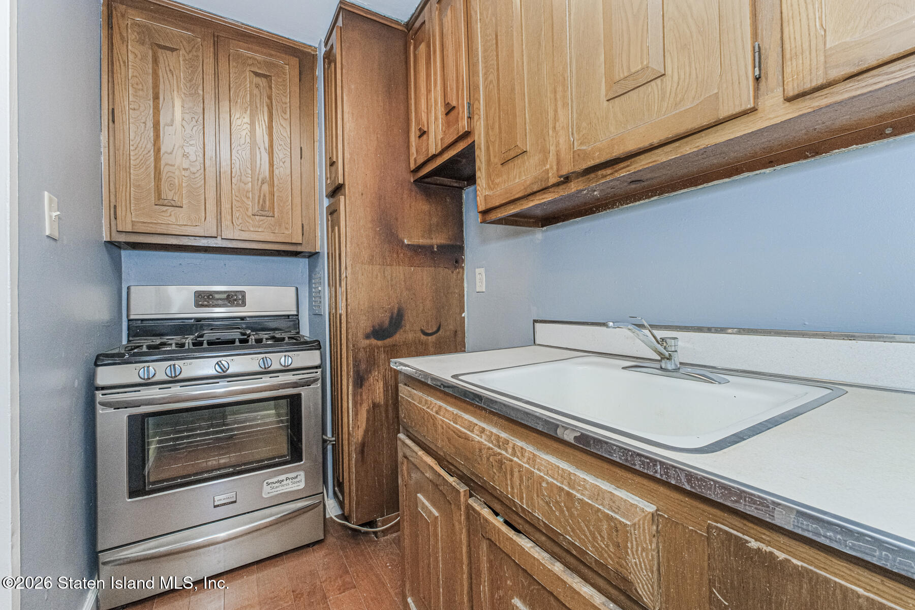 1000 Clove Road, Unit 7F Staten Island, NY 10301 - Photo 10 of 16 a kitchen with granite countertop cabinets stainless steel appliances and a sink