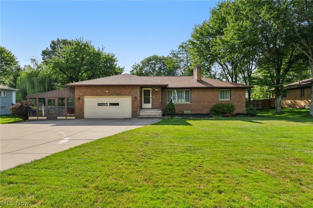 8310 Broadview Road Broadview Heights, OH 44147 - Photo 2 of 32 Brick exterior with a prominent driveway, attached garage, and a sunroom extension