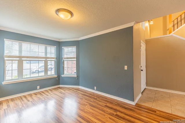a view of empty room with window and wooden floor