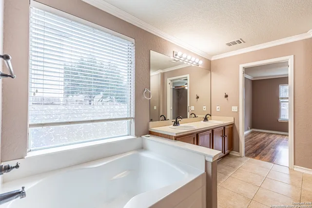 a bathroom with a tub sink and mirror