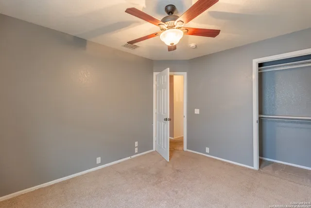an empty room with a fan and a fan