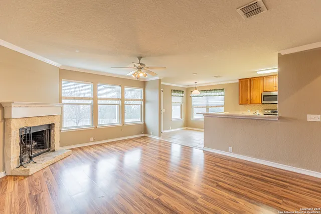 a view of an empty room with glass door and wooden floor