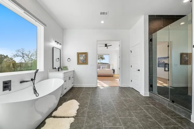 a bathroom with a white tub sink and mirror